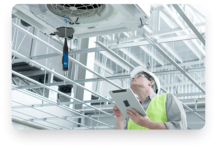 HVAC technician using Blü-Test probe on ceiling equipment